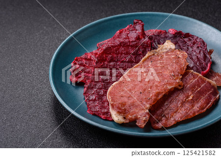Jerky, dried pork meat slices with salt and spices 125421582
