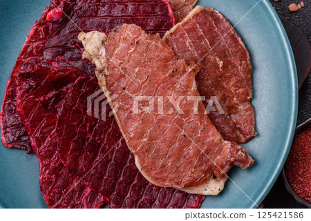 Jerky, dried pork meat slices with salt and spices Jerky, dried pork meat slices with salt and spices 125421586