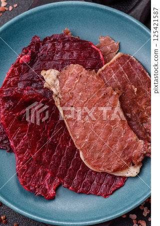 Jerky, dried pork meat slices with salt and spices Jerky, dried pork meat slices with salt and spices 125421587