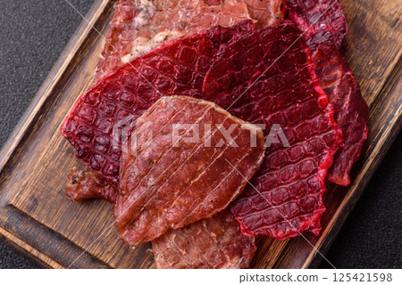 Jerky, dried pork meat slices with salt and spices Jerky, dried pork meat slices with salt and spices 125421598