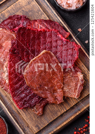 Jerky, dried pork meat slices with salt and spices 125421604