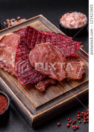 Jerky, dried pork meat slices with salt and spices 125421605