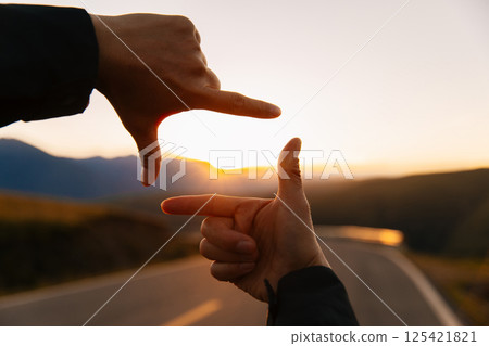 Hands in the shape of picture frame against the sunset 125421821