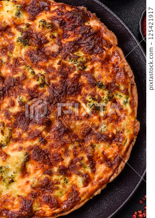 Delicious fresh quiche with broccoli, cheese, spices and herbs 125421917
