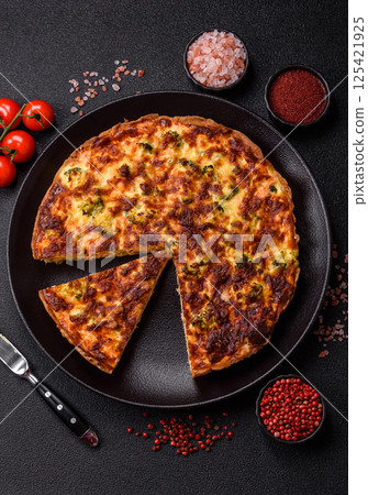 Delicious fresh quiche with broccoli, cheese, spices and herbs 125421925