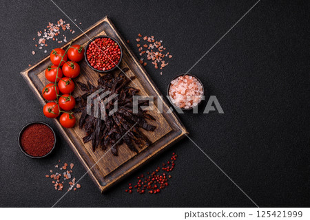 Jerky, dried horse meat or beef slices with salt and spices Jerky, dried horse meat or beef slices with salt and spices 125421999