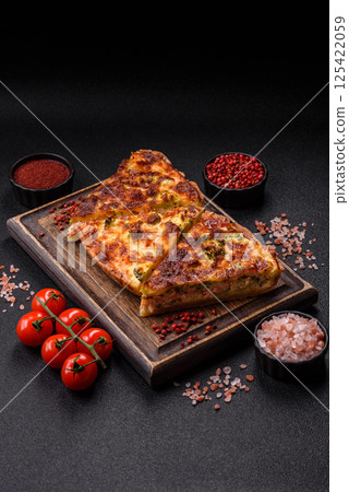 Delicious fresh quiche with broccoli, cheese, spices and herbs 125422059