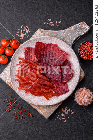 Dried beef slices, jerky, with cherry or plum flavor, salt and spices 125422263