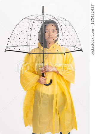 Asian woman with yellow raincoat and transparent umbrella 125422437