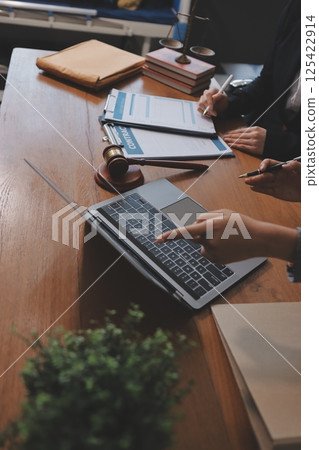 Judge gavel with Justice lawyers having team meeting at law firm background. Concepts of Law and Legal services. 125422914