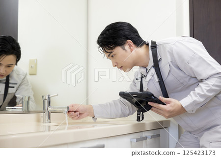 Housing sales: A man inspecting a bathroom 125423173