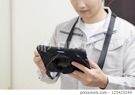 Housing sales: A man entering information into a tablet device Housing sales: A man entering information into a tablet device 125423249