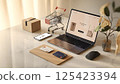 12Next Modern workspace featuring a laptop displaying an online shopping site. 125423394