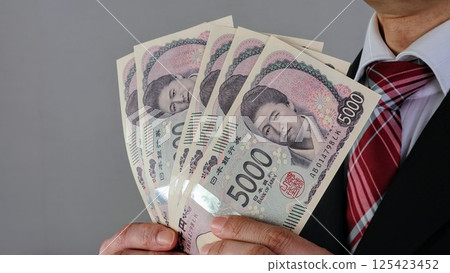 商人持有新版日本 5000 日元鈔票 商人持有新版日本 5000 日元鈔票 125423452