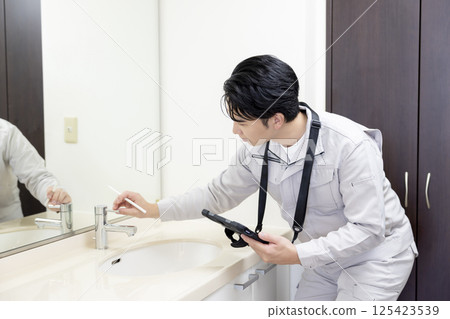 Housing sales: A man inspecting a bathroom 125423539