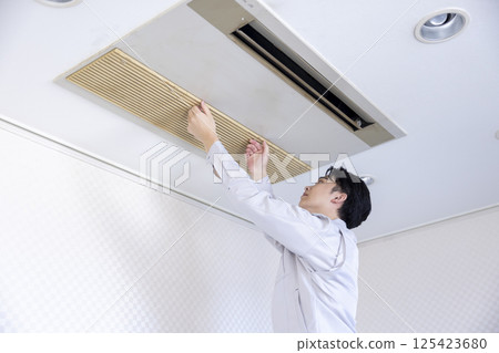 樓宇維護：一名身穿工作服的男子正在檢查空調 125423680
