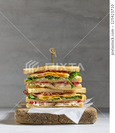club sandwich on wooden cutting board 125423710