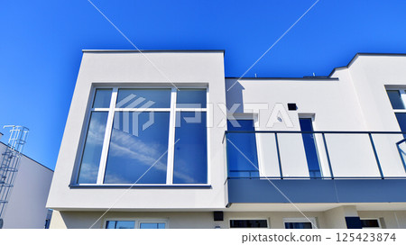 Terraced family homes in newly developed housing estate. The real estate market in the suburbs. New single family houses in a new development area. Residential homes with modern facade.  125423874