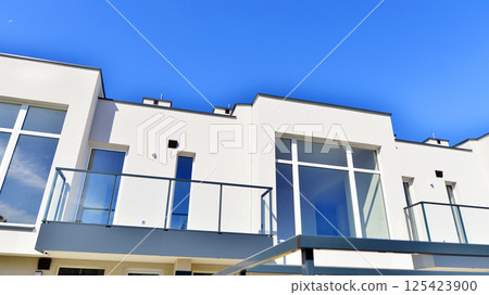 Terraced family homes in newly developed housing estate. The real estate market in the suburbs. New single family houses in a new development area. Residential homes with modern facade.  125423900