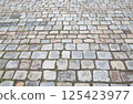 Granite cobblestone pavement. Ancient road surface. Stone sidewalk 125423977