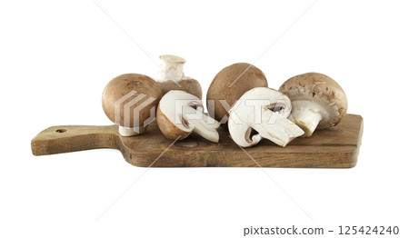 Several fresh cremini mushrooms, both whole and sliced in half, sit on a small wooden cutting board. Several fresh cremini mushrooms, both whole and sliced in half, sit on a small wooden cutting board. 125424240