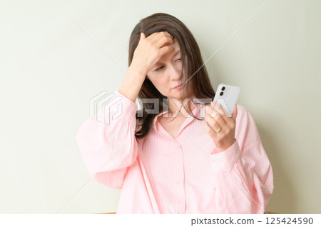 Senior woman tired from using a smartphone Senior woman tired from using a smartphone 125424590