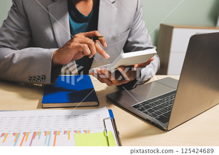 Working from home, Closeup business woman using laptop computer and analyzing financial report. 125424689