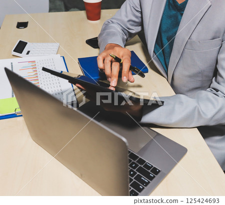 Working from home, Closeup business woman using laptop computer and analyzing financial report. Working from home, Closeup business woman using laptop computer and analyzing financial report. 125424693