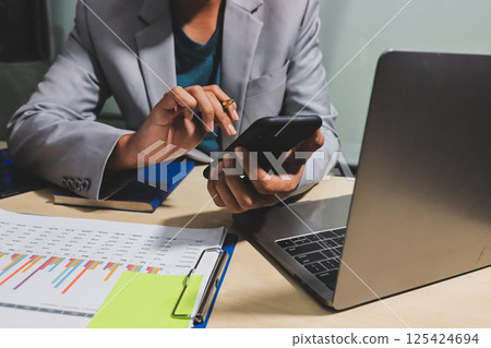 Working from home, Closeup business woman using laptop computer and analyzing financial report. 125424694