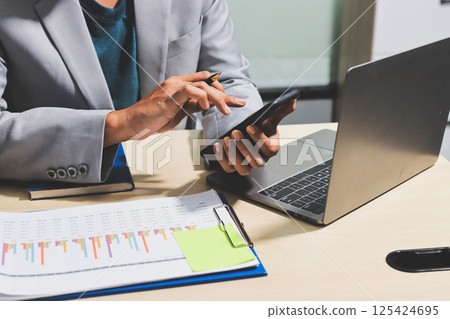 Working from home, Closeup business woman using laptop computer and analyzing financial report. Working from home, Closeup business woman using laptop computer and analyzing financial report. 125424695