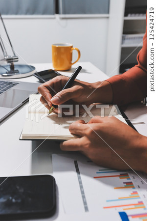 Working from home, Closeup business woman using laptop computer and analyzing financial report. Working from home, Closeup business woman using laptop computer and analyzing financial report. 125424719
