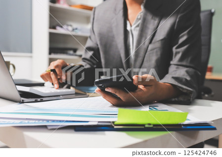 Working from home, Closeup business woman using laptop computer and analyzing financial report. Working from home, Closeup business woman using laptop computer and analyzing financial report. 125424746
