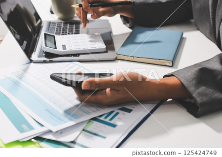 Working from home, Closeup business woman using laptop computer and analyzing financial report. Working from home, Closeup business woman using laptop computer and analyzing financial report. 125424749
