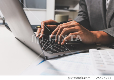 Working from home, Closeup business woman using laptop computer and analyzing financial report. 125424775