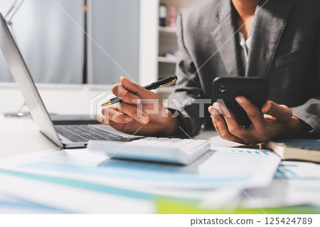 Working from home, Closeup business woman using laptop computer and analyzing financial report. 125424789