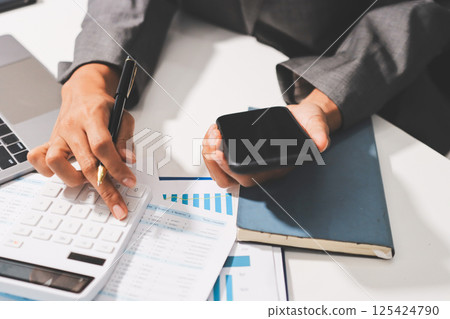 Working from home, Closeup business woman using laptop computer and analyzing financial report. 125424790
