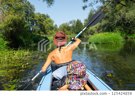 Family kayak trip. Mom and daughter rowing a boat on the river, a water hike, a summer adventure. Eco-friendly and extreme tourism, active and healthy lifestyle Family kayak trip. Mom and daughter rowing a boat on the river, a water hike, a summer adventure. Eco-friendly and extreme tourism, active and healthy lifestyle 125424859