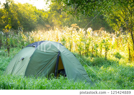 Installed tourist tent in a camping in nature in the forest. Domestic tourism, active summer holidays, family adventures. Ecotourism, sport, hike. Copy space, mock up Installed tourist tent in a camping in nature in the forest. Domestic tourism, active summer holidays, family adventures. Ecotourism, sport, hike. Copy space, mock up 125424889