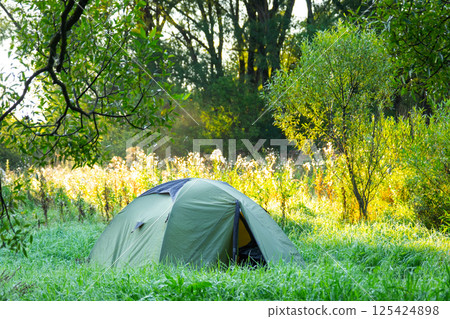 Installed tourist tent in a camping in nature in the forest. Domestic tourism, active summer holidays, family adventures. Ecotourism, sport, hike. Copy space, mock up Installed tourist tent in a camping in nature in the forest. Domestic tourism, active summer holidays, family adventures. Ecotourism, sport, hike. Copy space, mock up 125424898