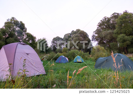 Installed tourist tent in a camping in nature in the forest. Domestic tourism, active summer holidays, family adventures. Ecotourism, sport, hike. Copy space, mock up Installed tourist tent in a camping in nature in the forest. Domestic tourism, active summer holidays, family adventures. Ecotourism, sport, hike. Copy space, mock up 125425025