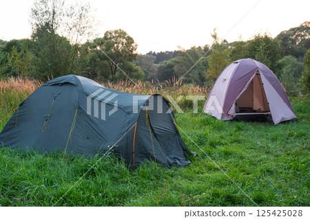 Installed tourist tent in a camping in nature in the forest. Domestic tourism, active summer holidays, family adventures. Ecotourism, sport, hike. Copy space, mock up 125425028