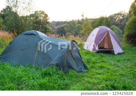 Installed tourist tent in a camping in nature in the forest. Domestic tourism, active summer holidays, family adventures. Ecotourism, sport, hike. Copy space, mock up Installed tourist tent in a camping in nature in the forest. Domestic tourism, active summer holidays, family adventures. Ecotourism, sport, hike. Copy space, mock up 125425029