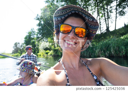 Man and woman couple, child 8 years old, selfies are happy in family kayak trip rowing boat on the river, water hike, a summer adventure. Eco-friendly and extreme tourism, active and healthy lifestyle 125425036