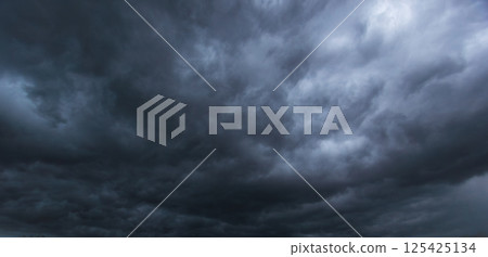 The dark sky filled with swirling clouds forebodes an approaching windstorm, showcasing the power of nature's forces and the dramatic shifts in weather during turbulent atmospheric conditions. 125425134