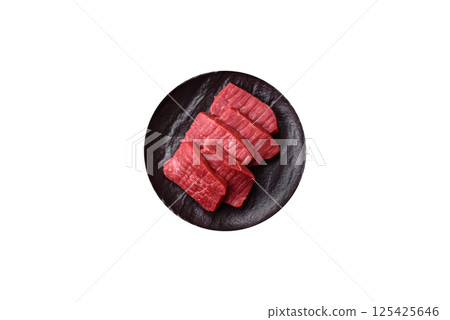 Raw beef tenderloin cut into slices with salt and spices 125425646