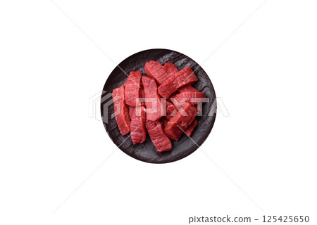 Raw beef tenderloin cut into slices with salt and spices Raw beef tenderloin cut into slices with salt and spices 125425650