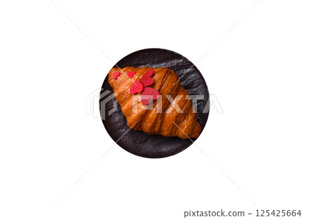 Sweet crispy croissant decorated with red hearts Sweet crispy croissant decorated with red hearts 125425664