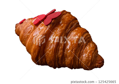 Sweet crispy croissant decorated with red hearts Sweet crispy croissant decorated with red hearts 125425665