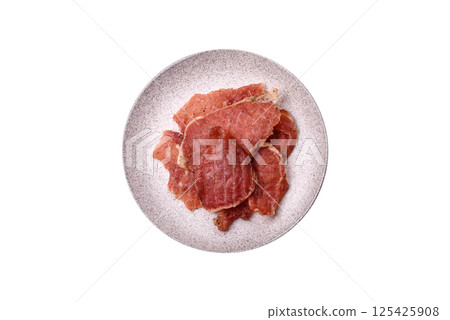 Jerky, dried pork meat slices with salt and spices 125425908