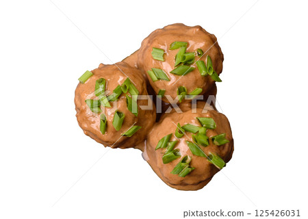 Meatballs with salt and spices in creamy caramel sauce 125426031
